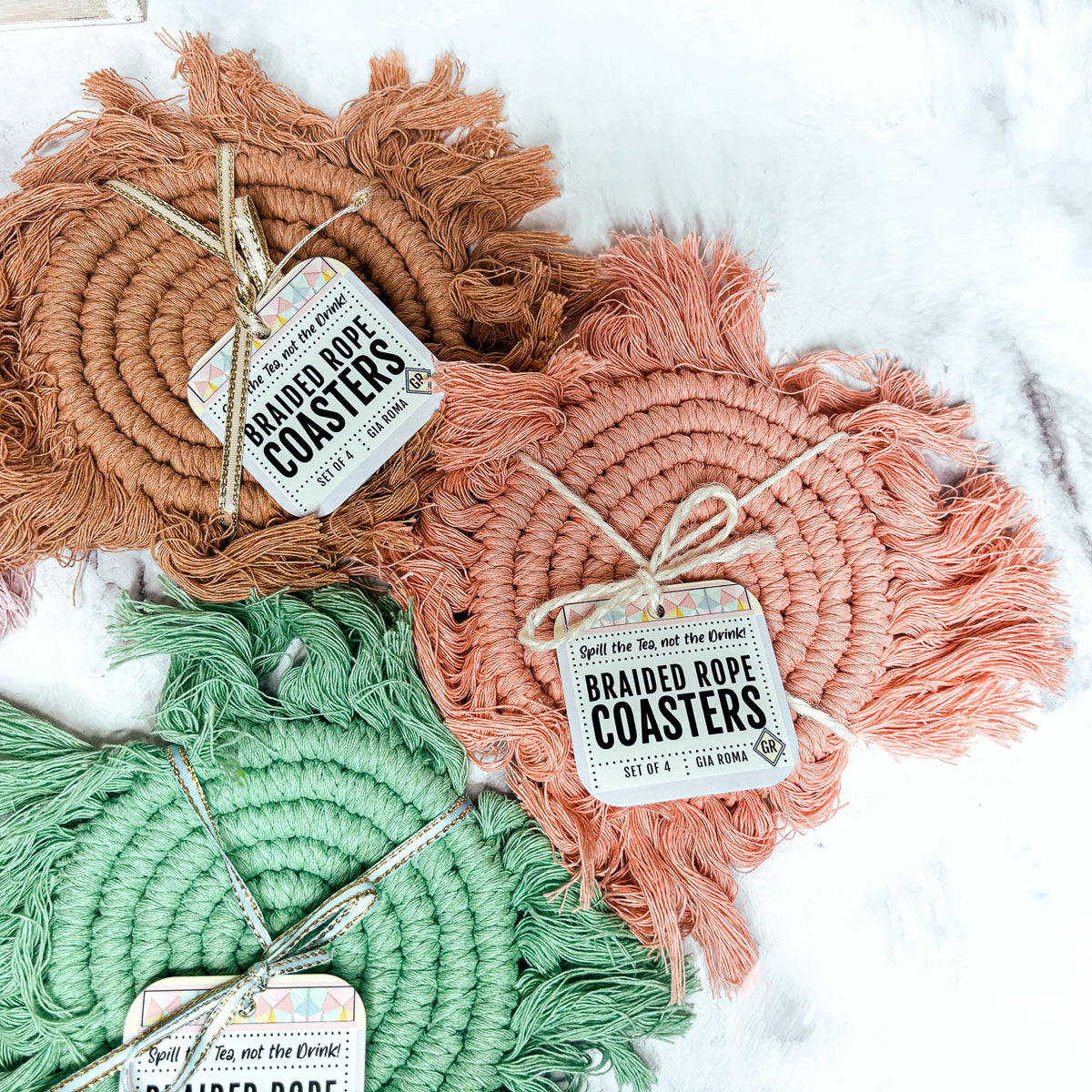Braided rope tassel coasters set in brown, orange, mint green, and coral with hanging tags