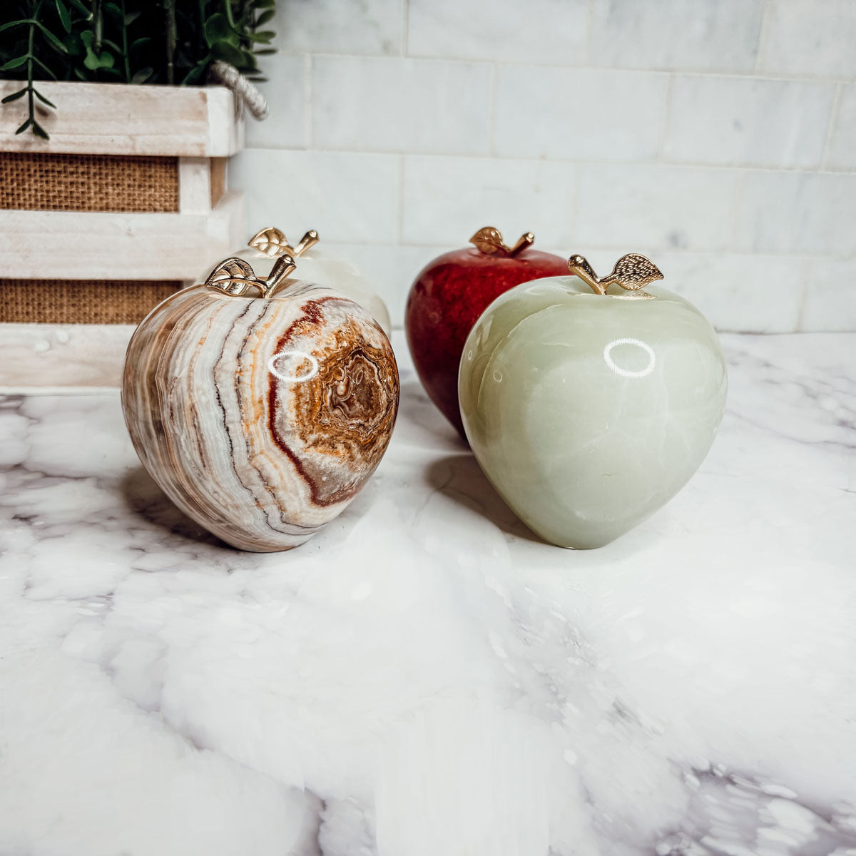 Heart-shaped paperweights side by side: brown marbled and cream with gold tops.