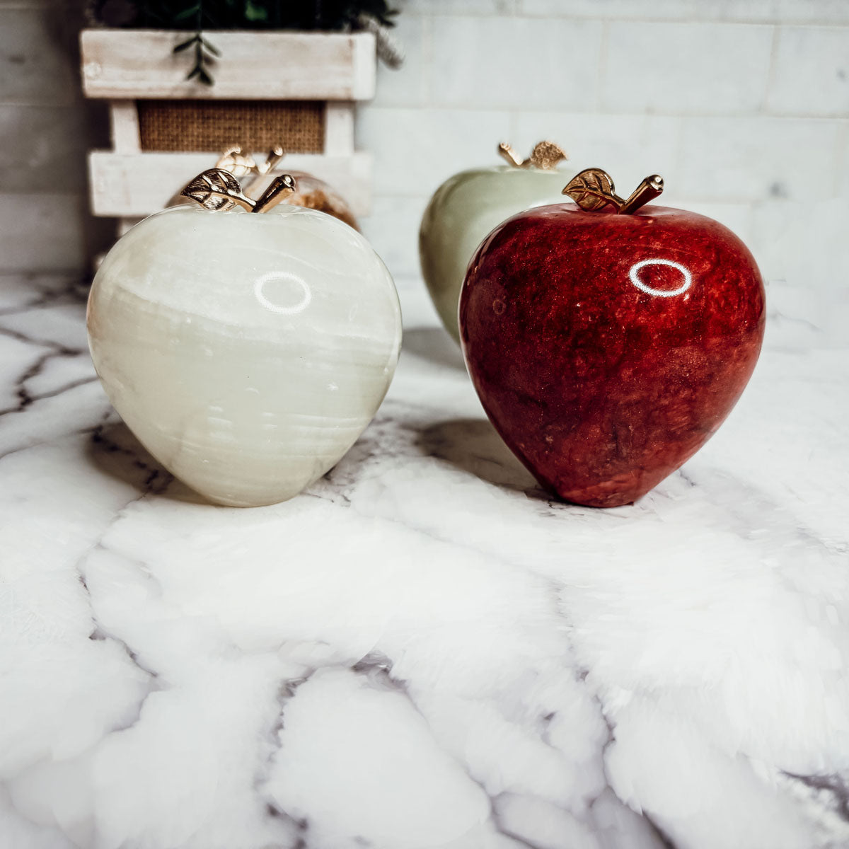 Cream white and red heart-shaped paperweights with gold tops on a surface.