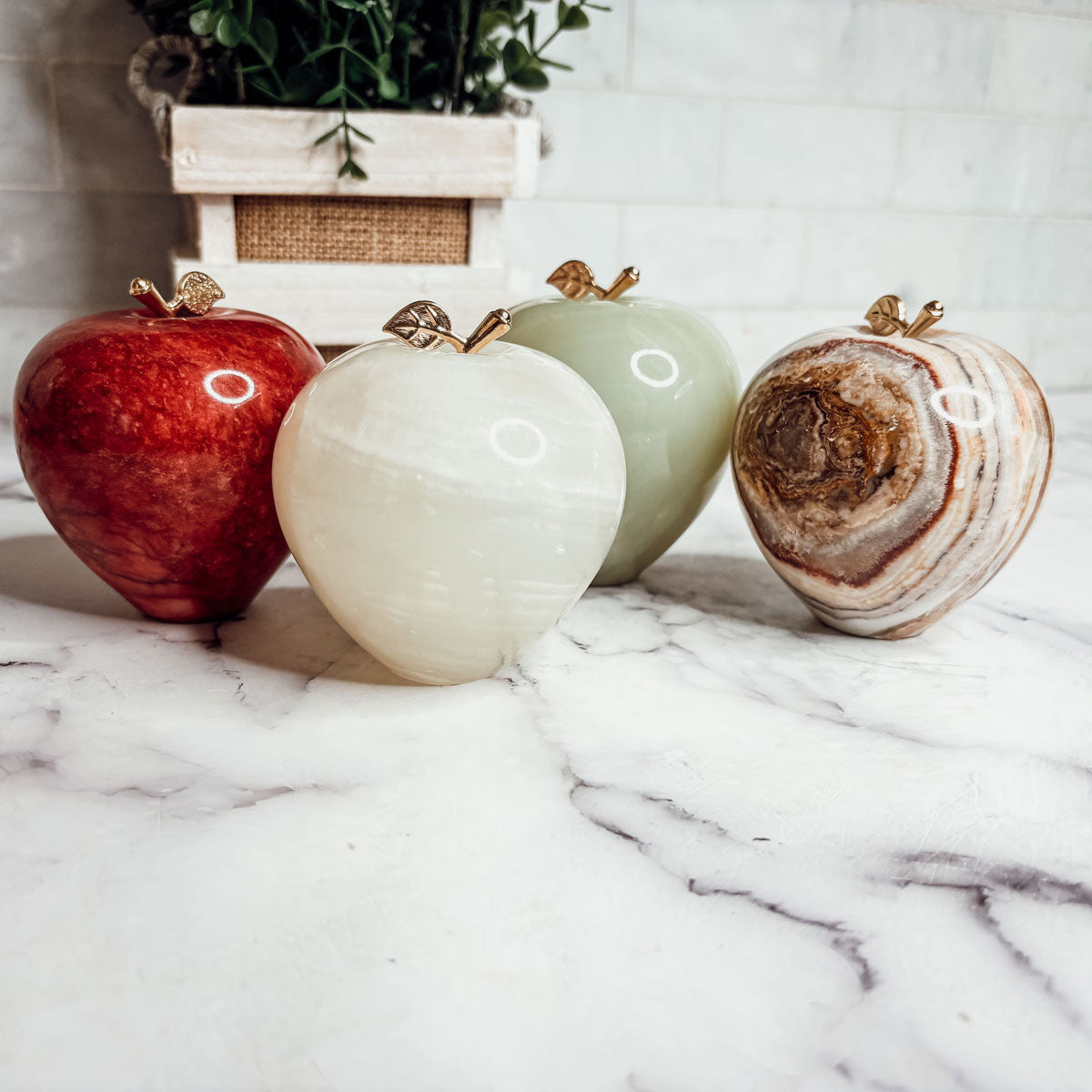 Heart-shaped paperweight set: red, white, and brown marbled stones with gold tops.