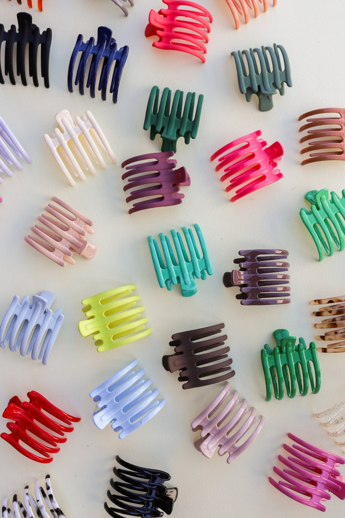 Hair claw clips in mixed colors, laid out in a variety of shapes and finishes