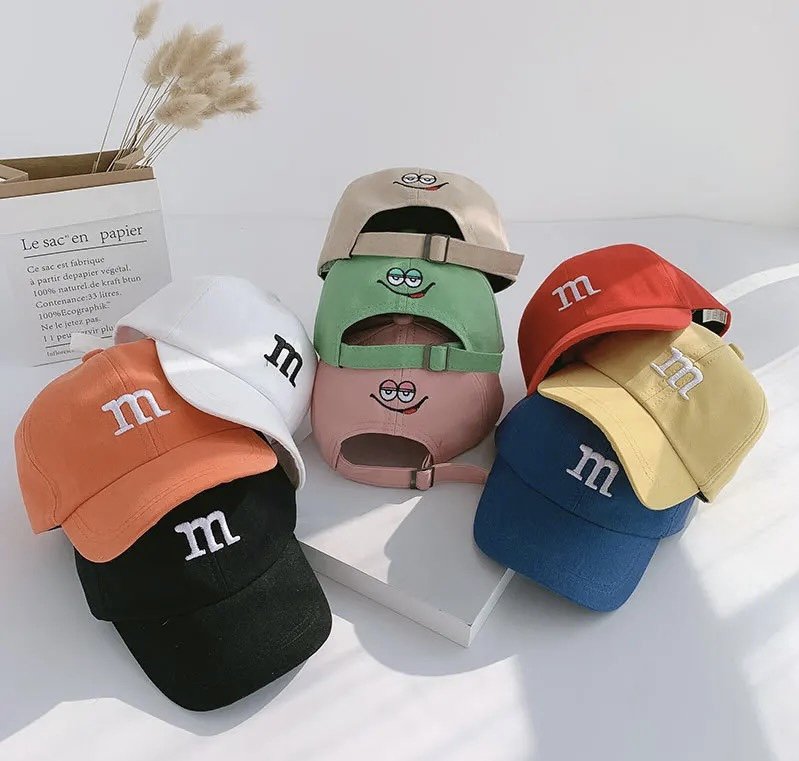Set of kids baseball caps with colorful characters and “m” logos