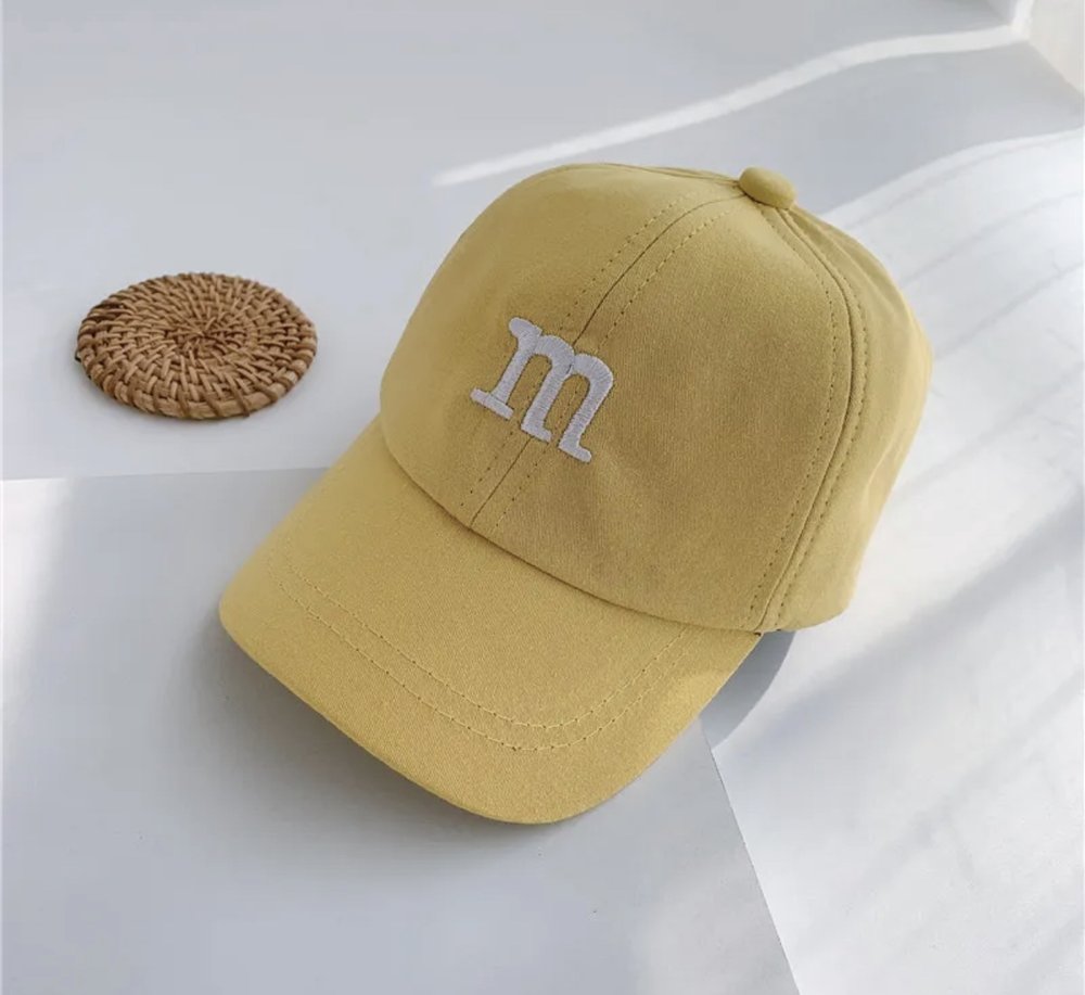 Kids baseball cap in yellow with an “m” logo on the front panel