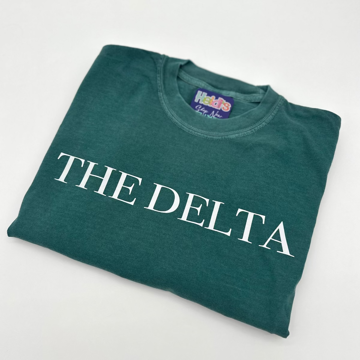 Deep green crew-neck graphic T-shirt with white “THE DELTA” text on the chest.