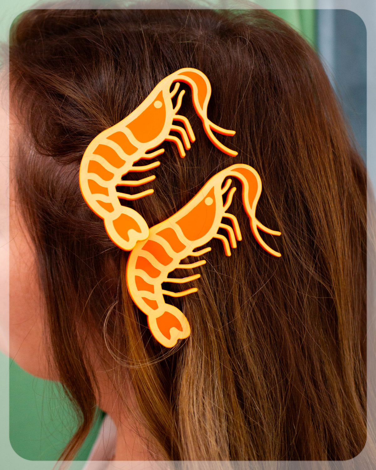 Orange shrimp hair barrettes on dark brown hair, two-piece clip set