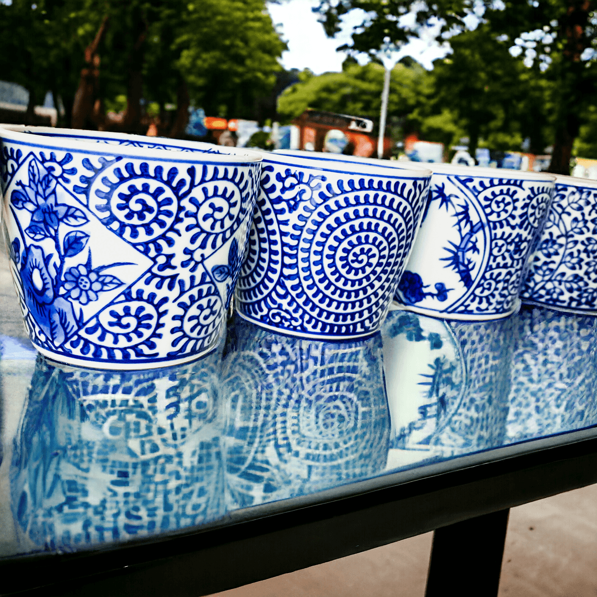 Mini chinoiserie cachepots close-up of blue-and-white patterned mini ceramic planters on ledge