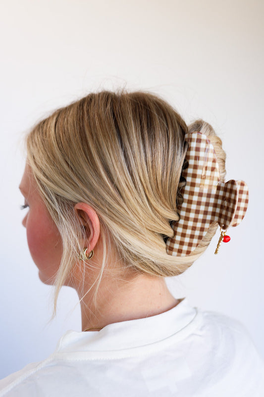 Brown gingham hair claw with red tomato charm clipped into a blonde bun