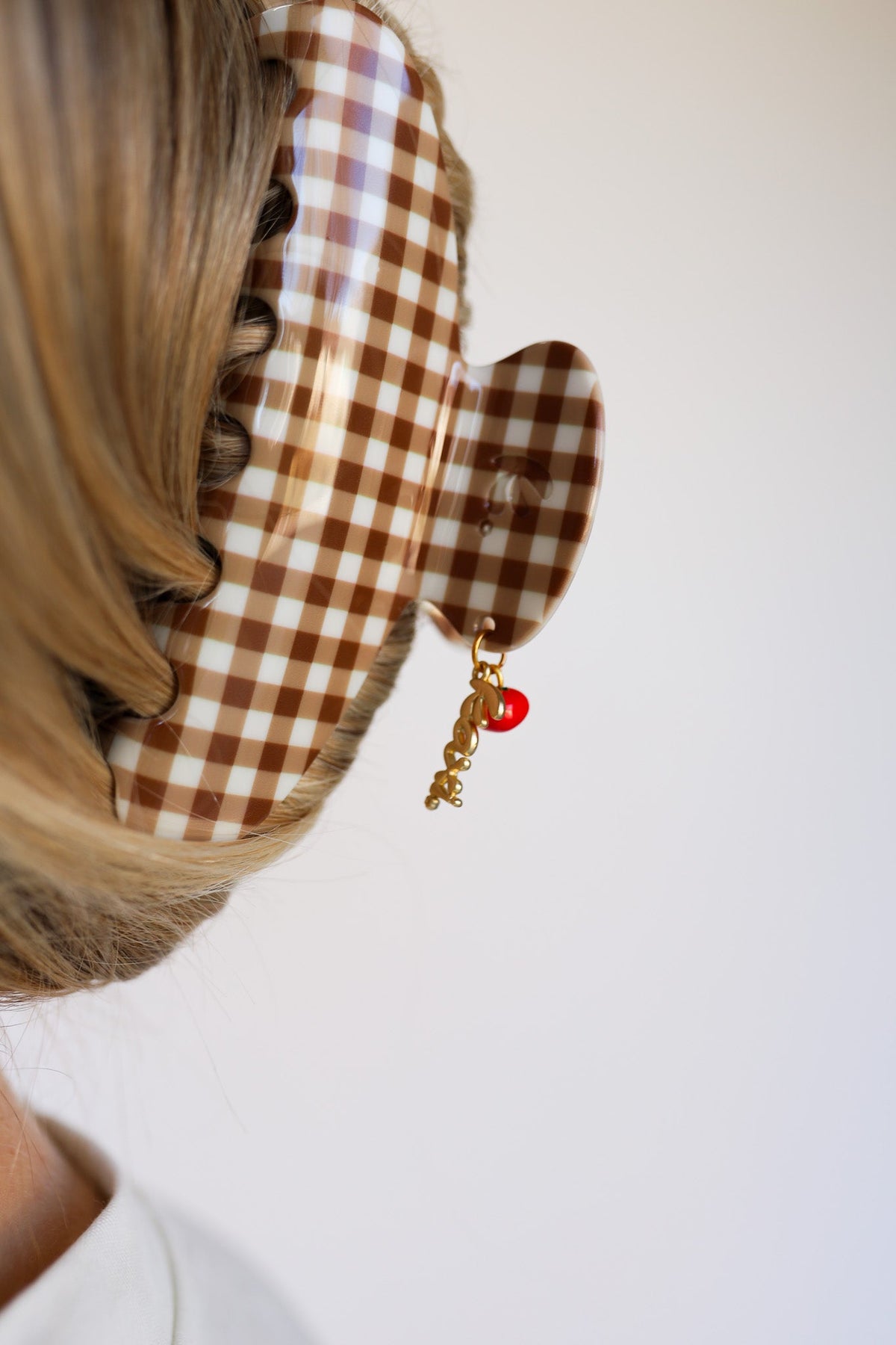 Brown gingham hair claw with red tomato charm and small gold-tone dangling beads
