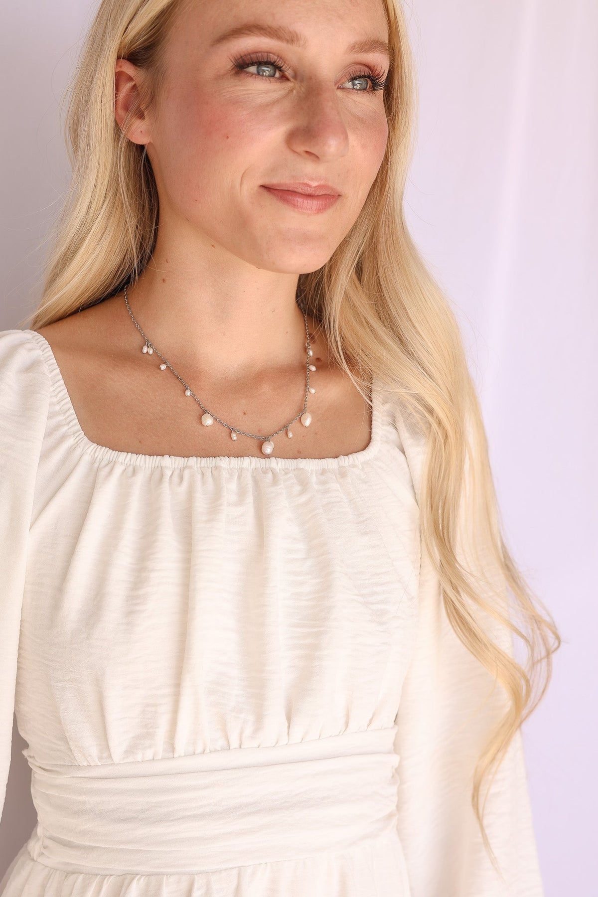 Silver Calypso Necklace with pearl drops worn over a white dress