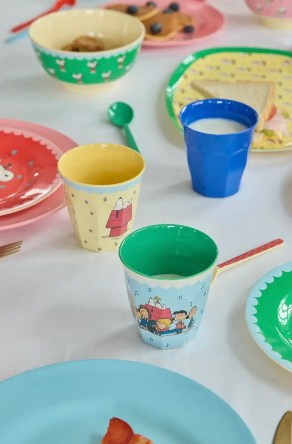 Colorful printed cups and bowls on a table with cartoon designs