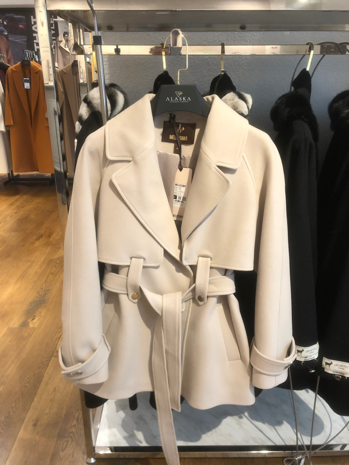 Nude cashmere-wool blend coat on a hanger, showing wide lapels, belt, and pockets