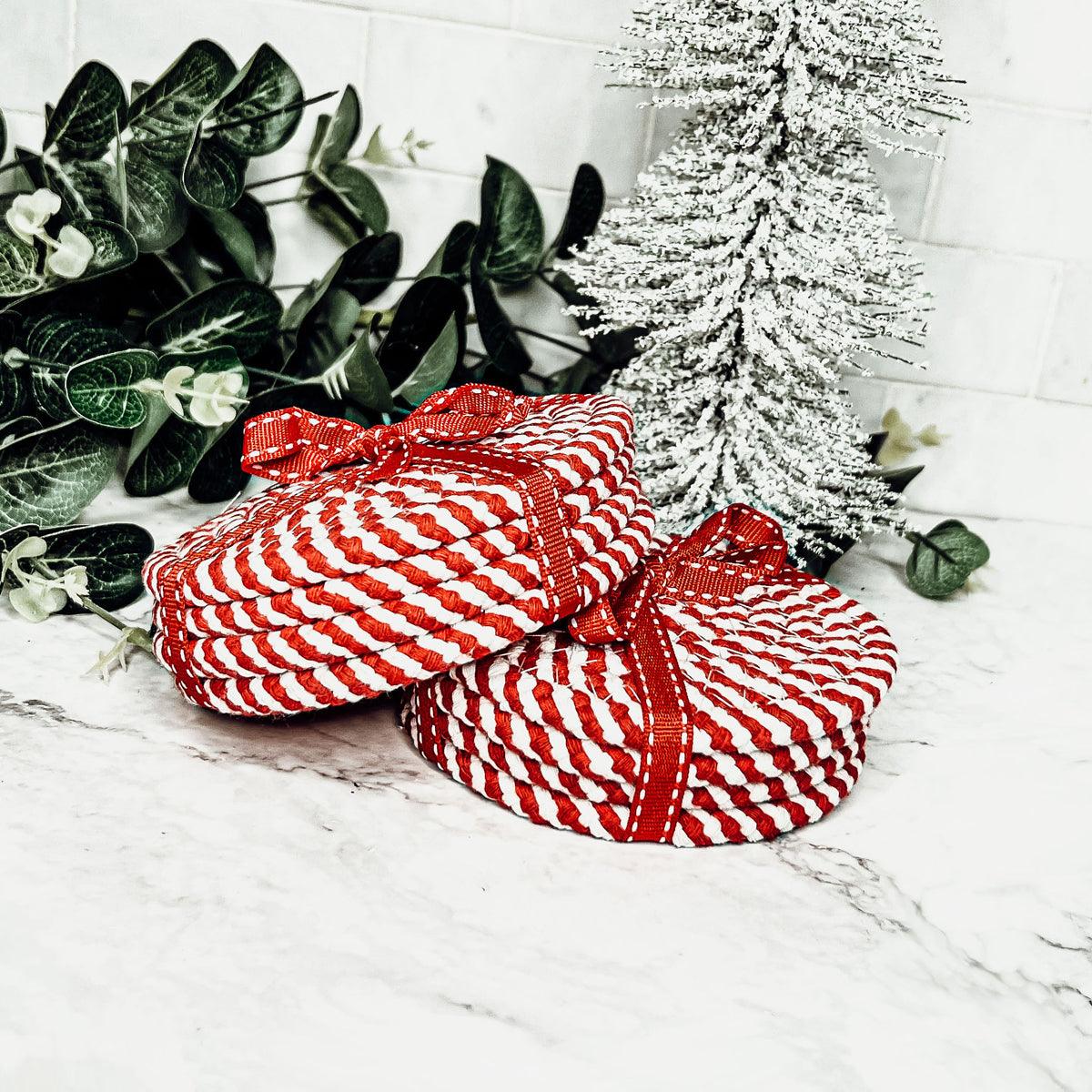 Set of 4 red-and-white candy cane striped braided rope coasters with ribbon bows