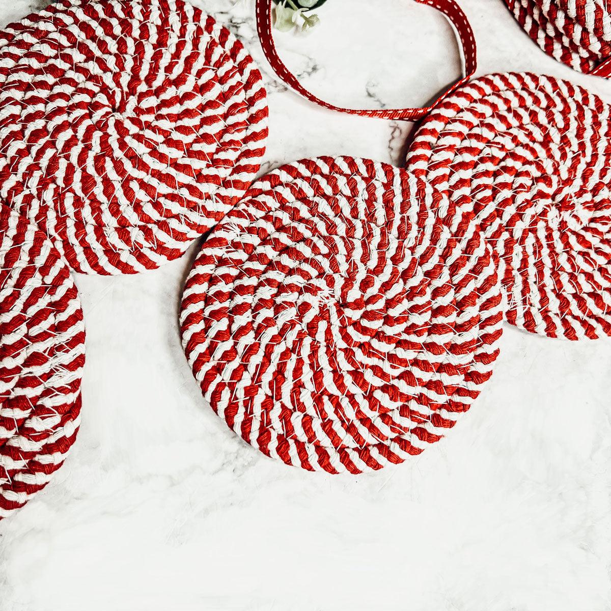 Close-up of red-and-white striped braided rope coasters with loop hanger