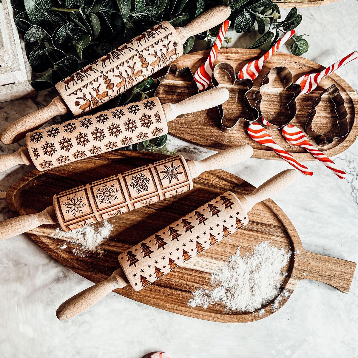 Rolling pin set with assorted engraved Christmas patterns beside cookie cutters and striped accents