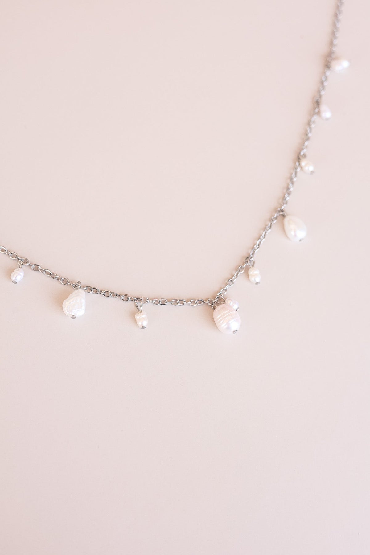 Close-up of the silver Calypso Necklace chain and pearl drops