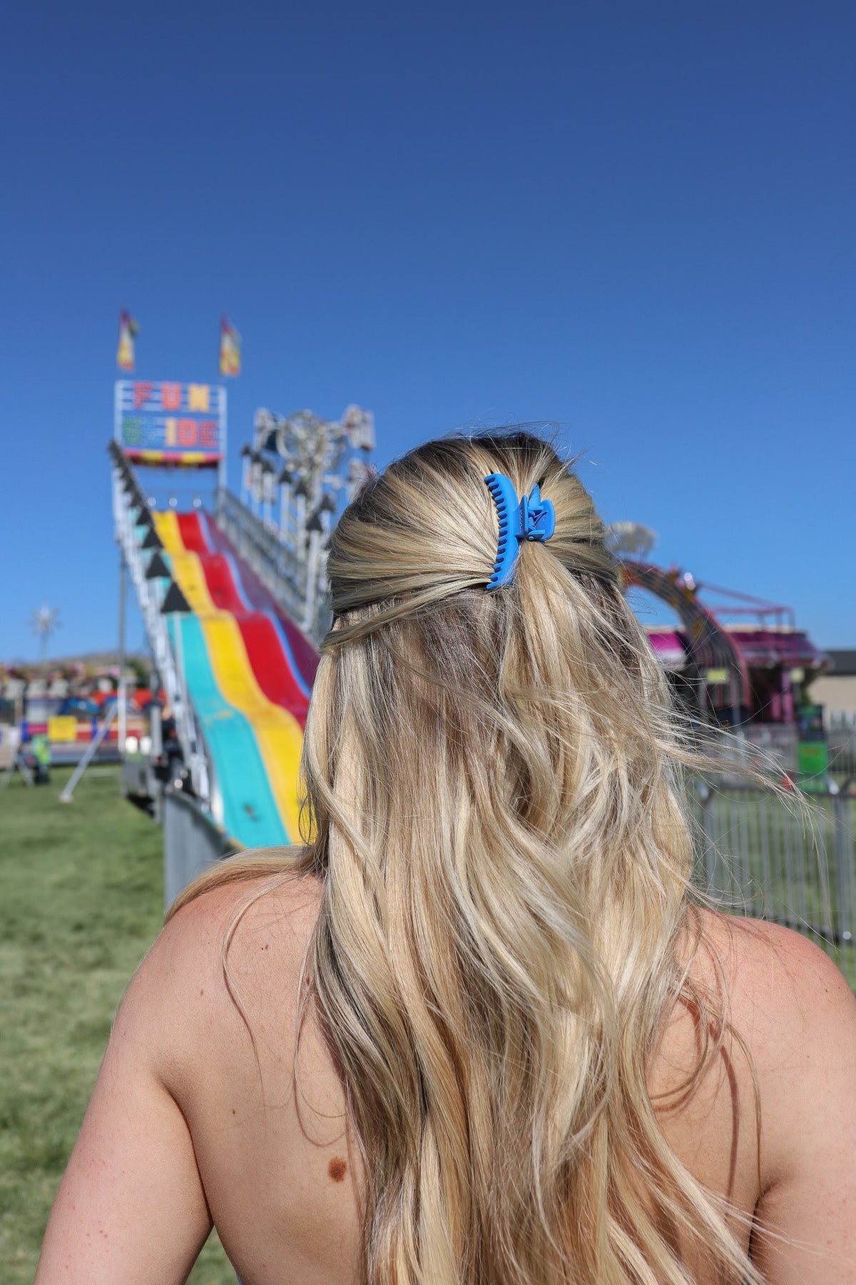 Matte mini claw hair clip, blue, on long hair updo at outdoor event