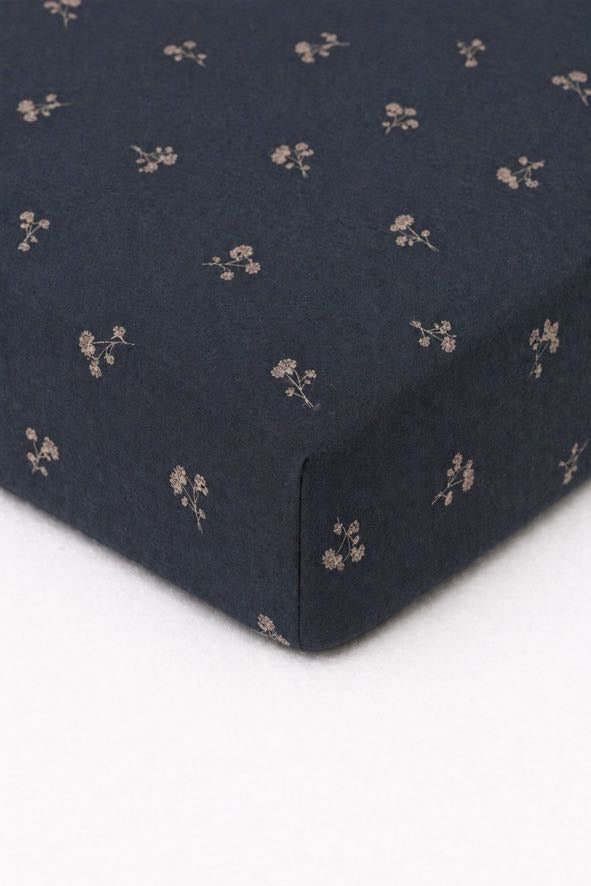 Blue crib sheet with a small tan dandelion print