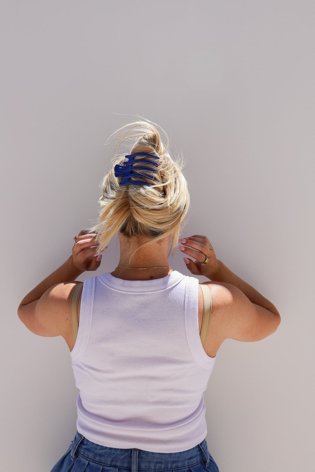 Wide lay-down claw hair clip in hair, glossy deep blue, secure wide hold.