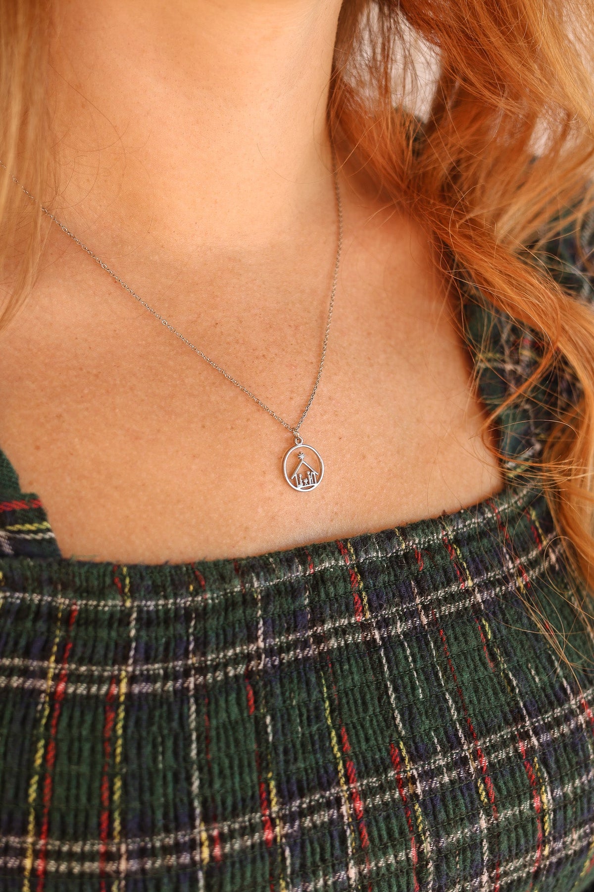 Silver Nativity necklace with round pendant worn at the neckline