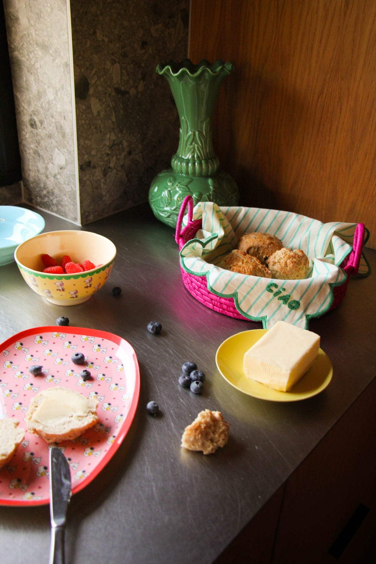 Yellow Peanuts-style character-print bowl with snacks, on a table surface.