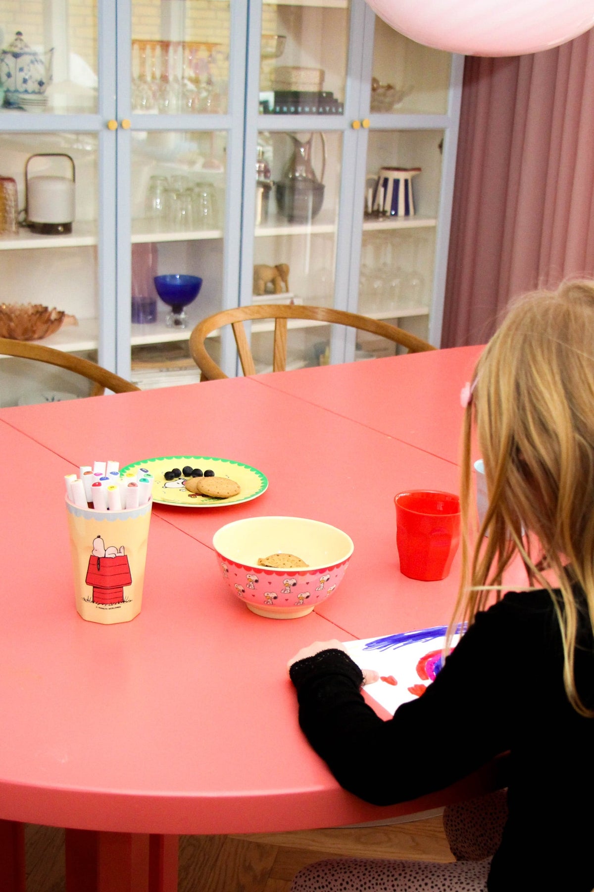 Pink character-print bowl on red tabletop