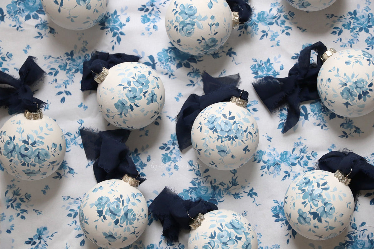 White floral ornaments with blue hand-painted roses and navy bows