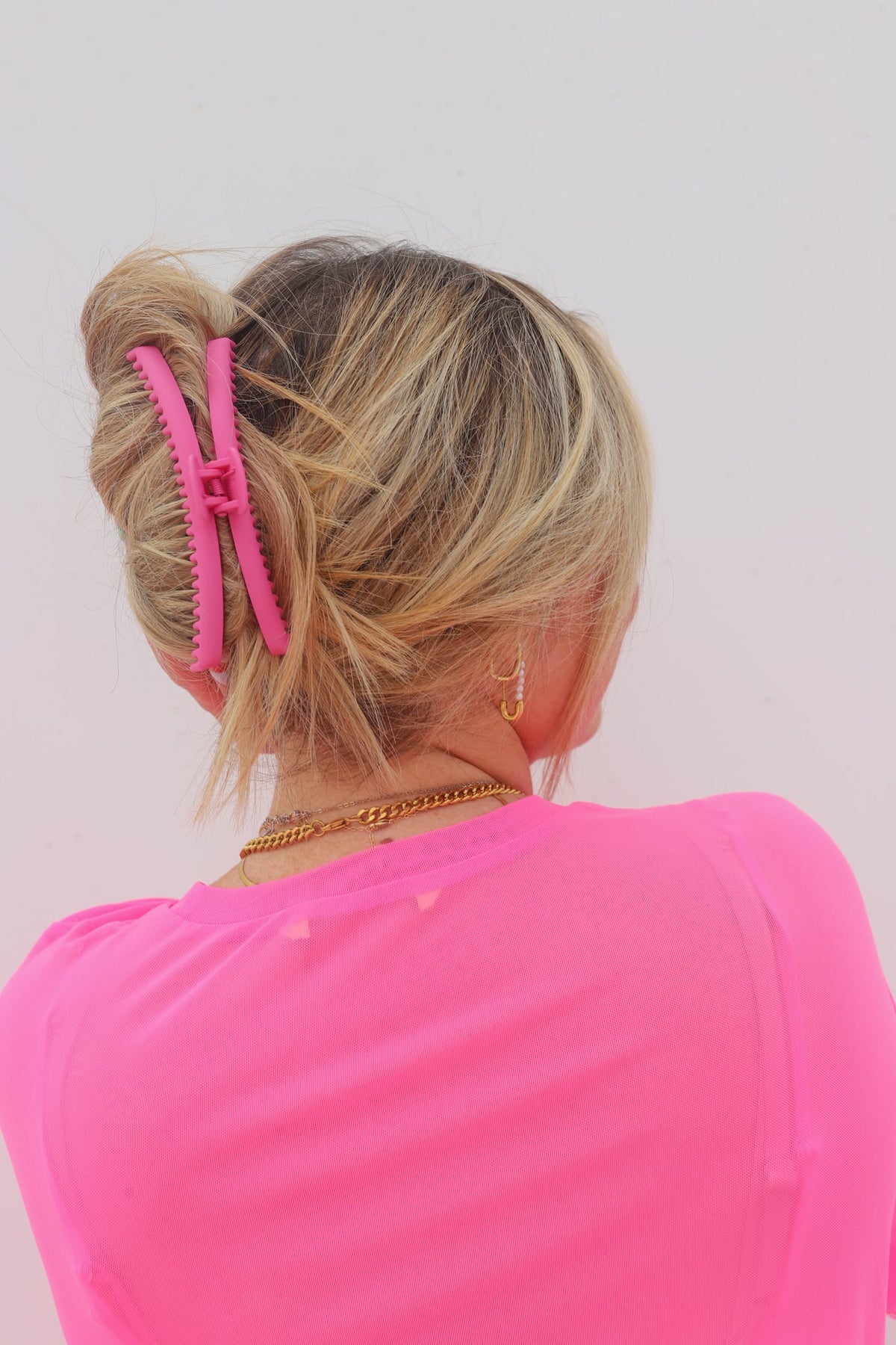 Hot pink hair claw clip on blonde hair, back view
