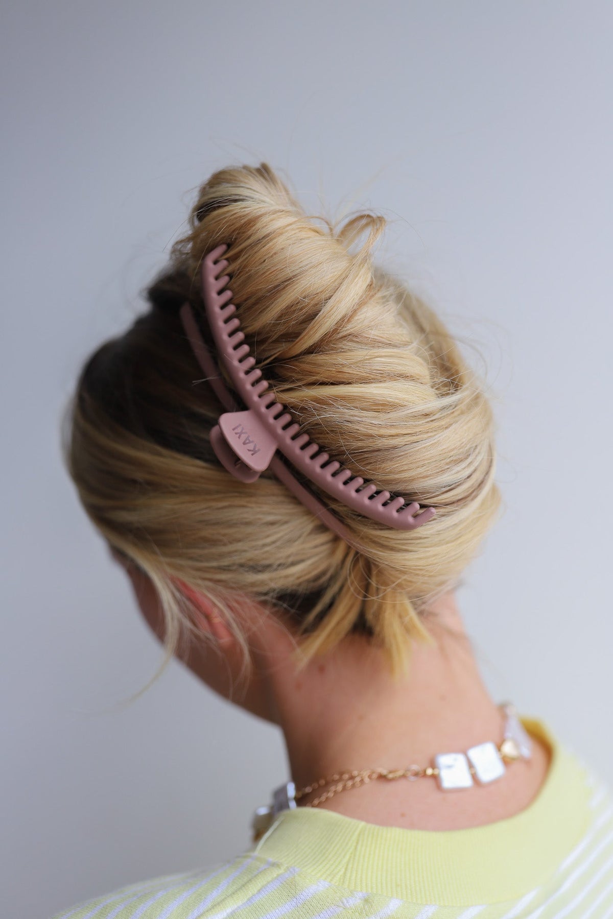 Mauve hair claw clip holding blonde hair, top view