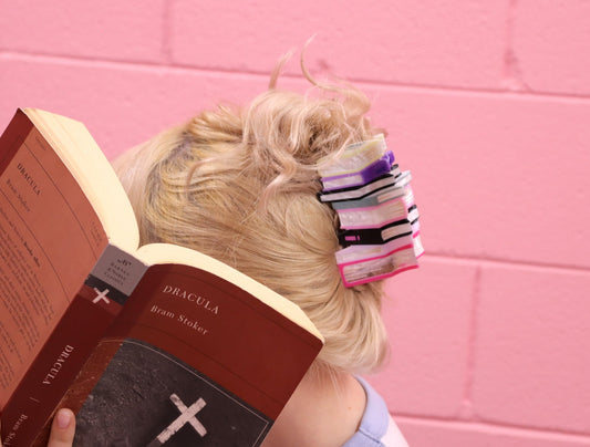 Book stack hair claw with mini book tiers in purple, pink, and black