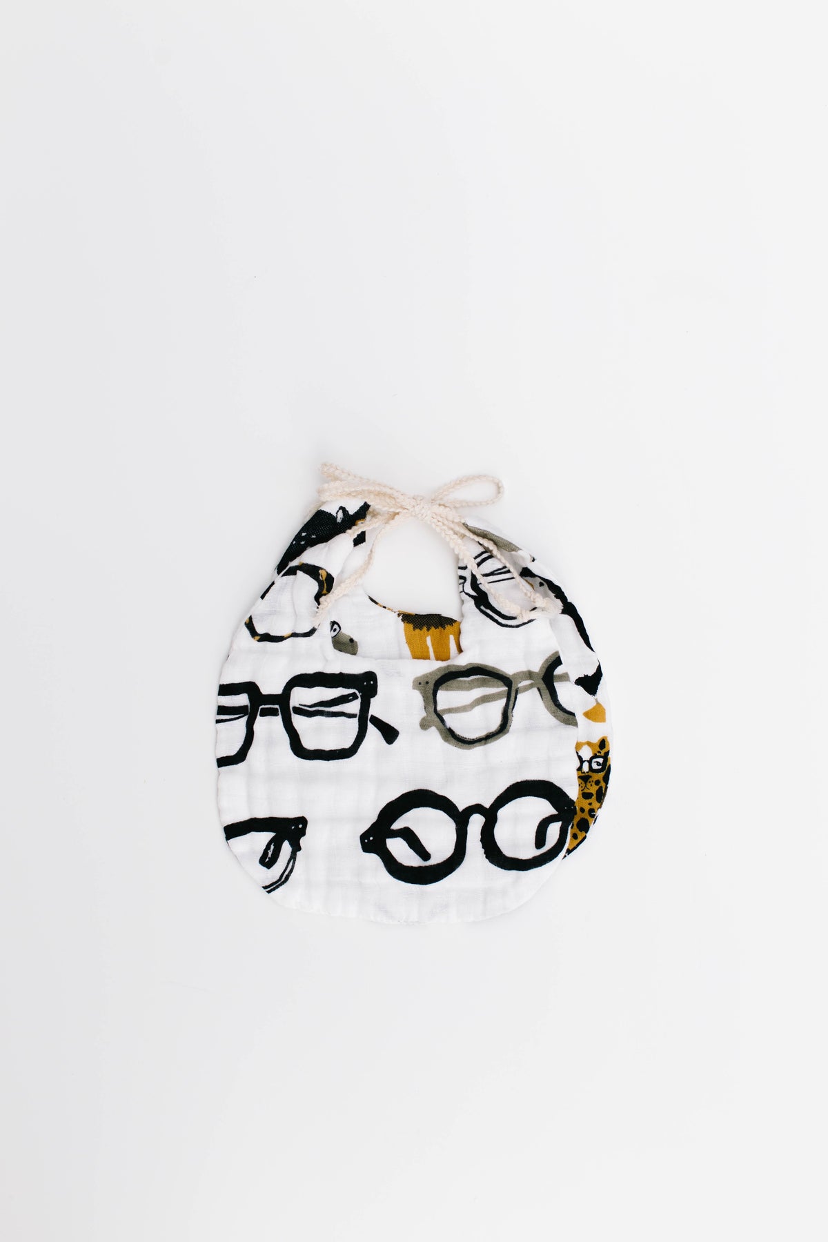 Animal print baby bib with zoo animals, including a yellow dog, on cream fabric