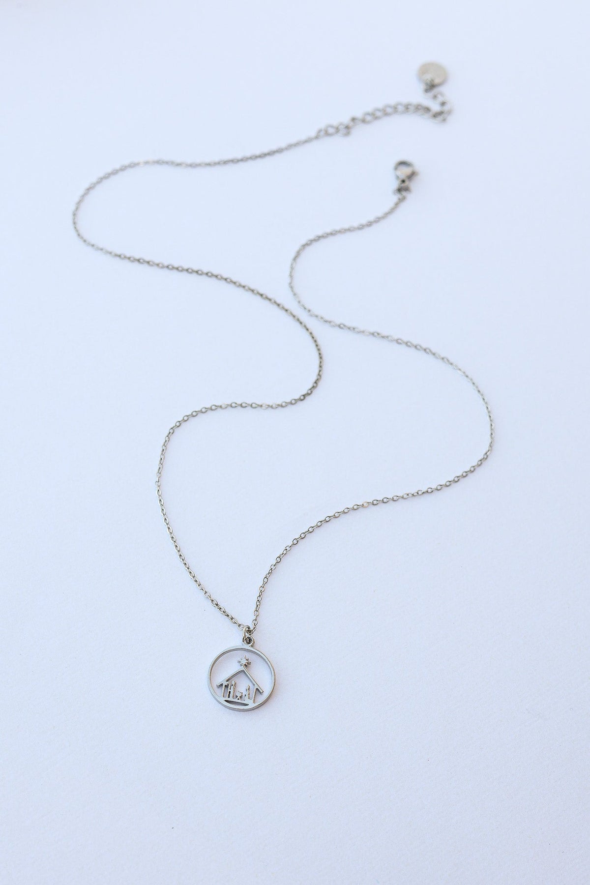 Silver Nativity necklace laid flat, showing the chain and pendant