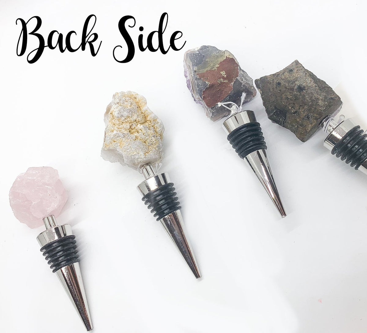 Wine bottle stoppers showing different crystal backs with black ribbed collars and metal tips