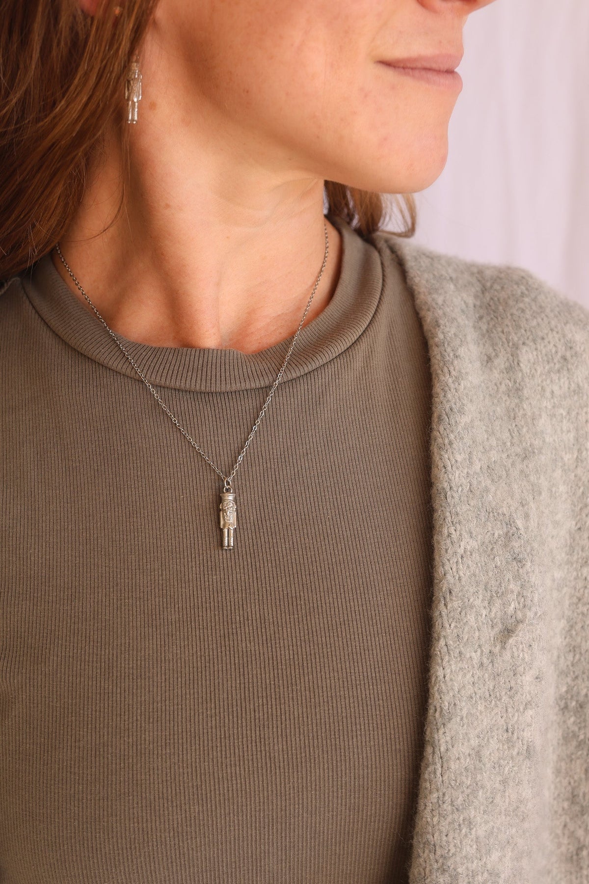Silver nutcracker necklace worn over a ribbed top