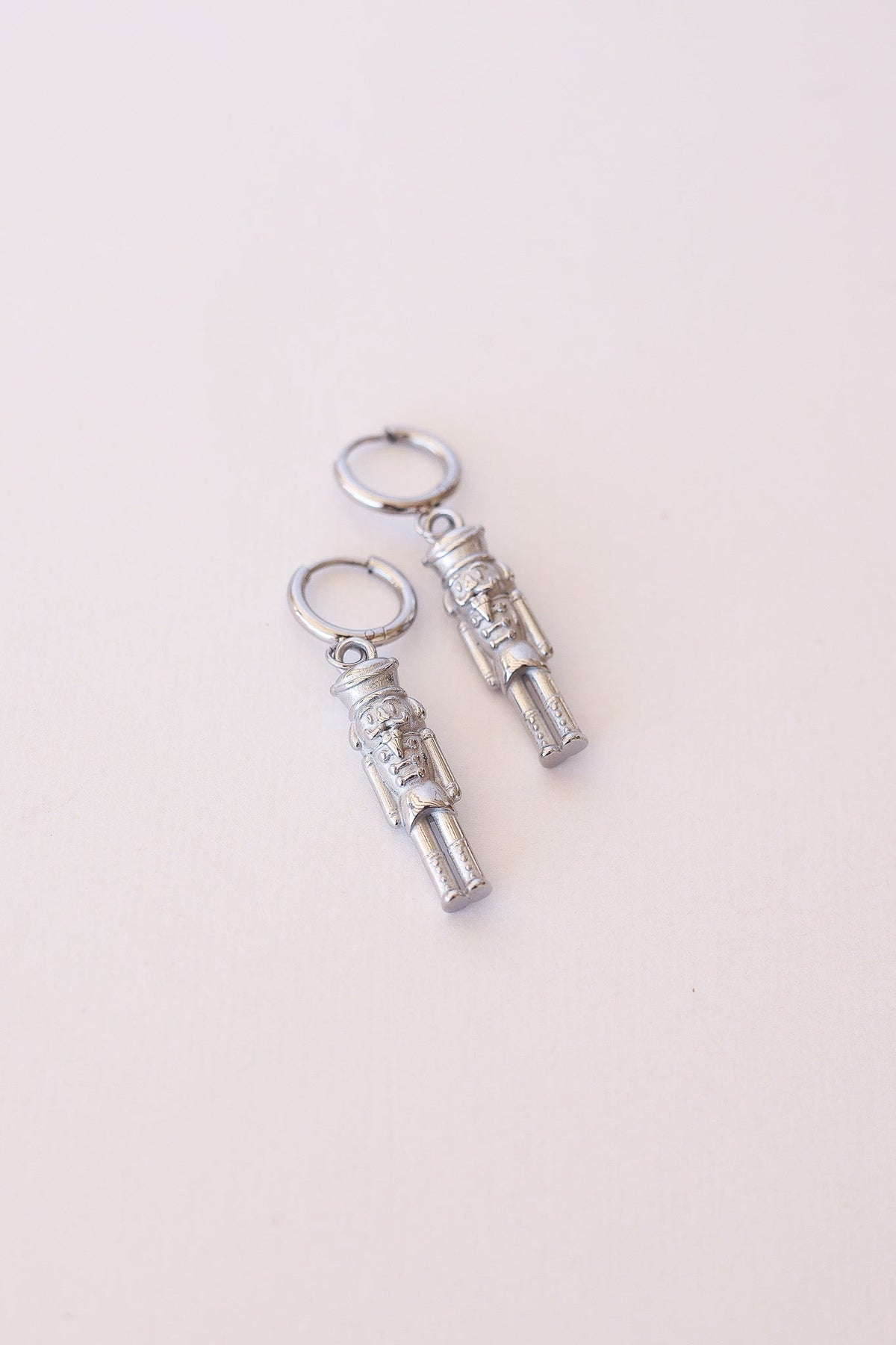 Silver Nutcracker Huggie Hoop earrings with detailed nutcracker charms