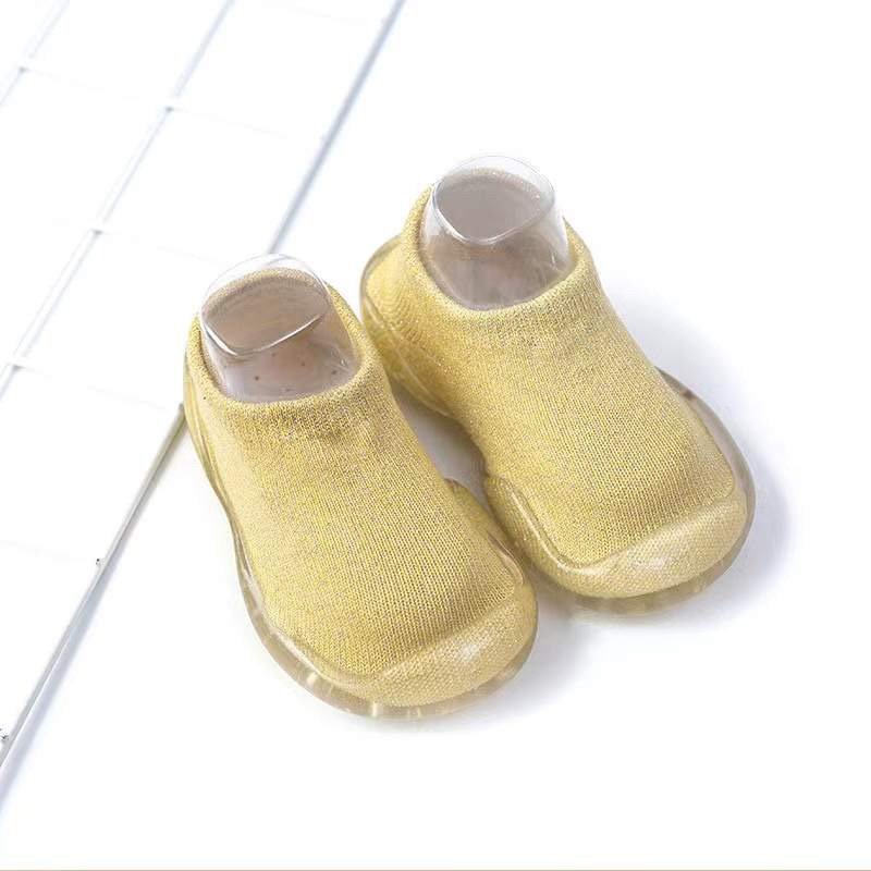 Yellow baby sock shoes with clear soles, knit upper and rounded toe