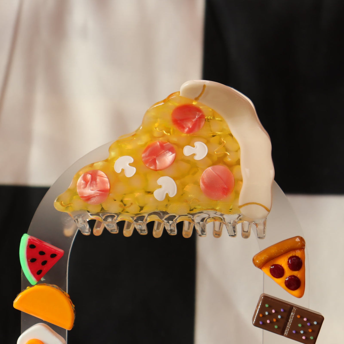 Pizza slice-shaped hair claw with pink toppings and white cheese center