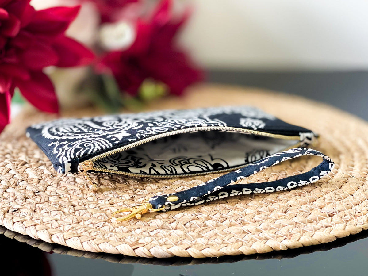 Quilted wristlet pouch with paisley print; open interior shows lining and zip track