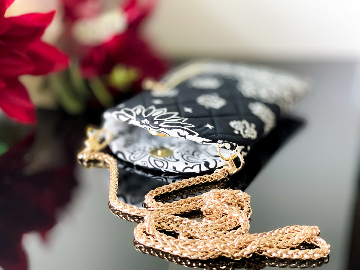 Black phone sling pouch with bandana print and long gold chain strap