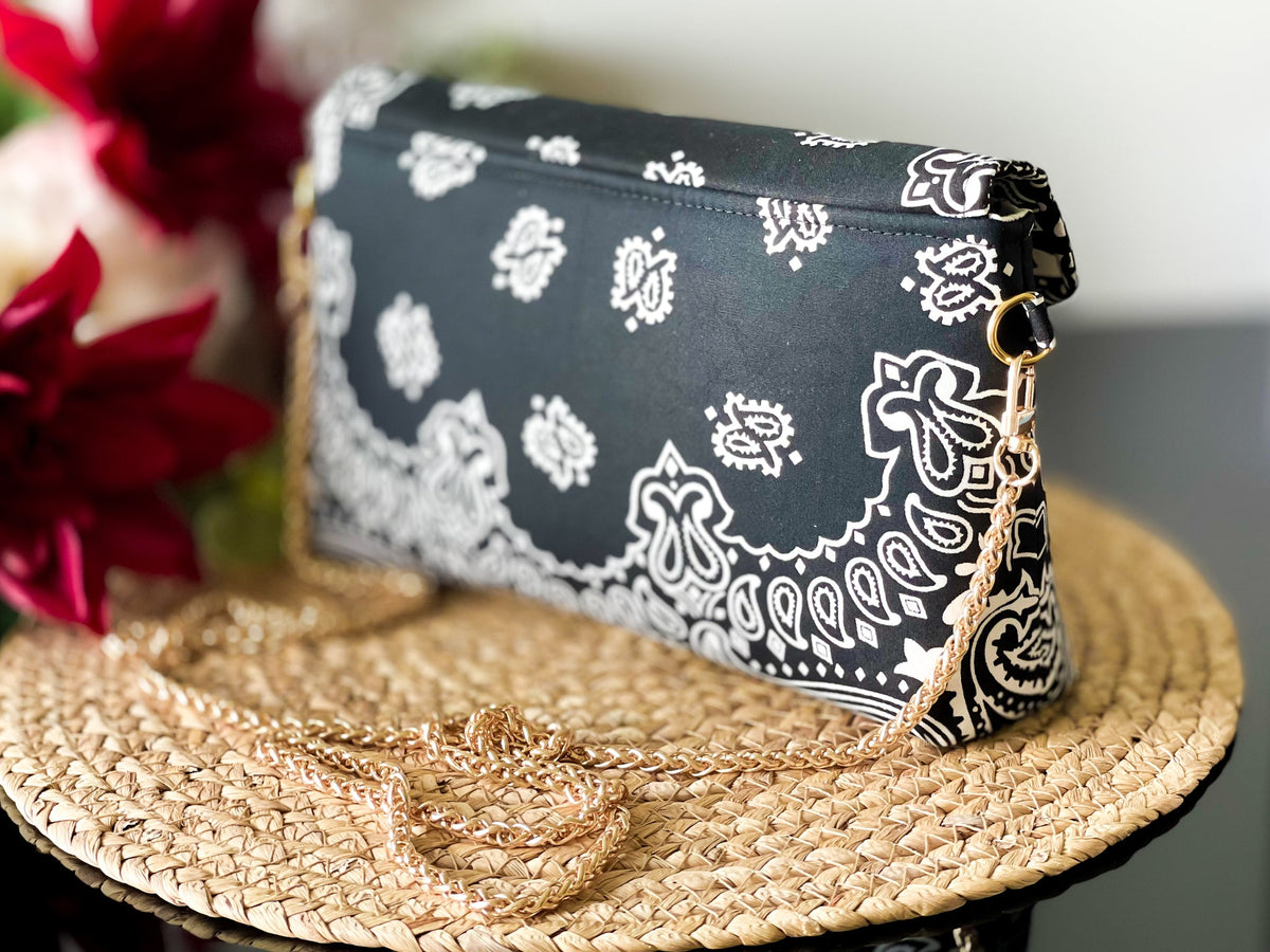 Black bandana print crossbody sling bag with side view gold chain strap and clasp