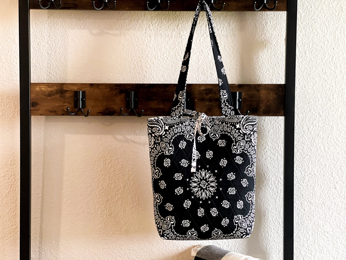 Medium tote bag hanging with double rope handles, black-and-white paisley print