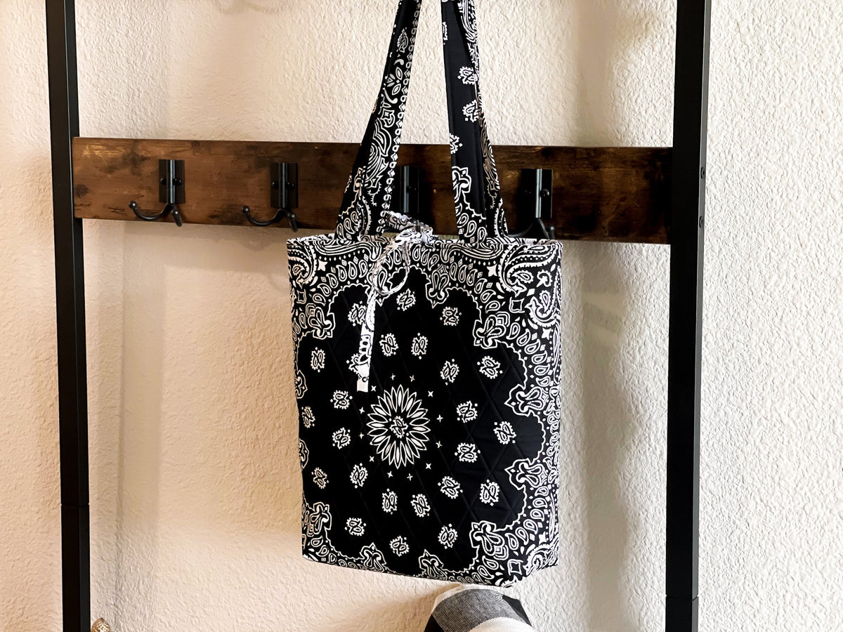 Book tote bag hanging on hook with black-and-white bandana pattern and sturdy handles