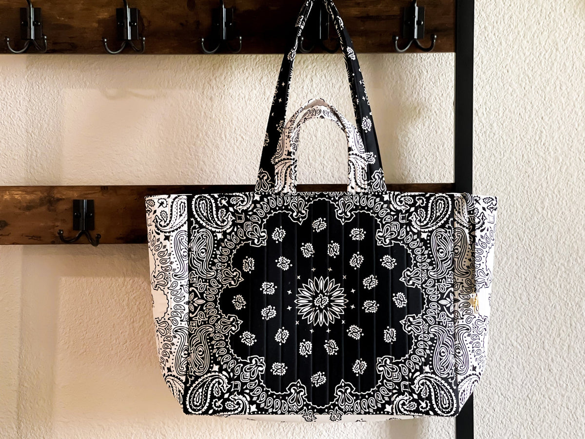 Large quilted tote bag hanging, black-and-white paisley pattern