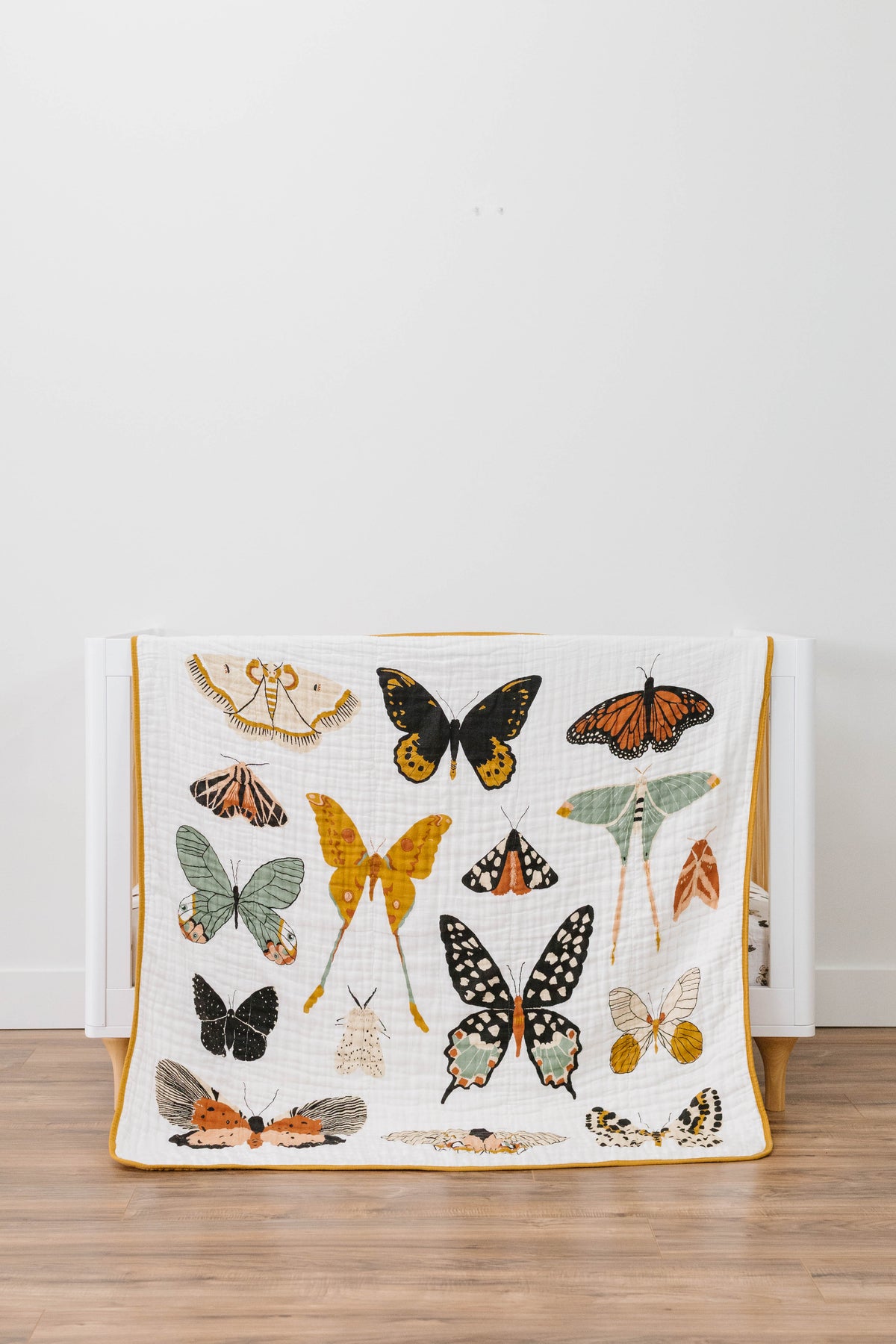 Butterfly collector quilt with multicolor butterfly prints on white fabric, yellow border