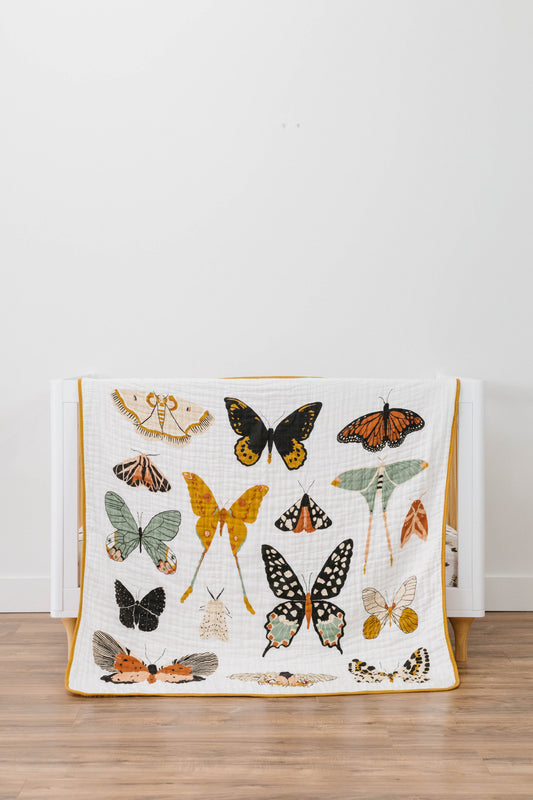 Butterfly collector quilt with multicolor butterfly prints on white fabric, yellow border
