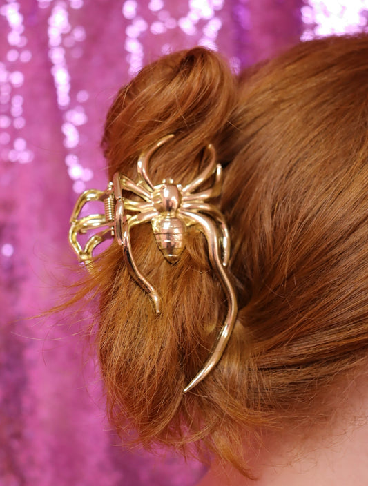 Gold-tone spider hair claw with curved prongs and raised web details