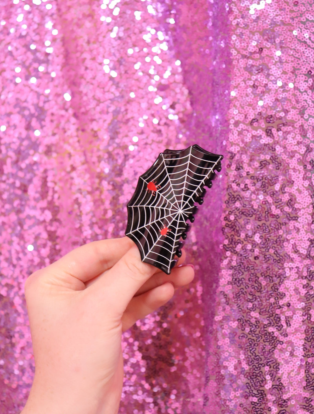 Spider-web hair claw in black with red accents, small claw clip