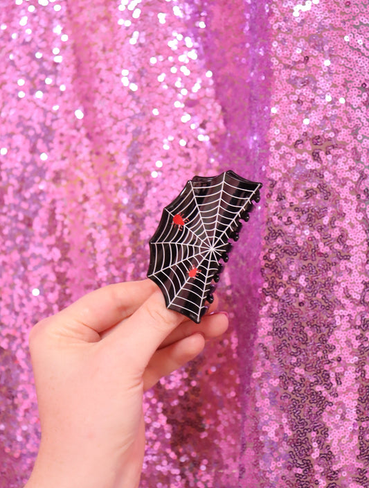 Spider-web hair claw in black with red accents, small claw clip