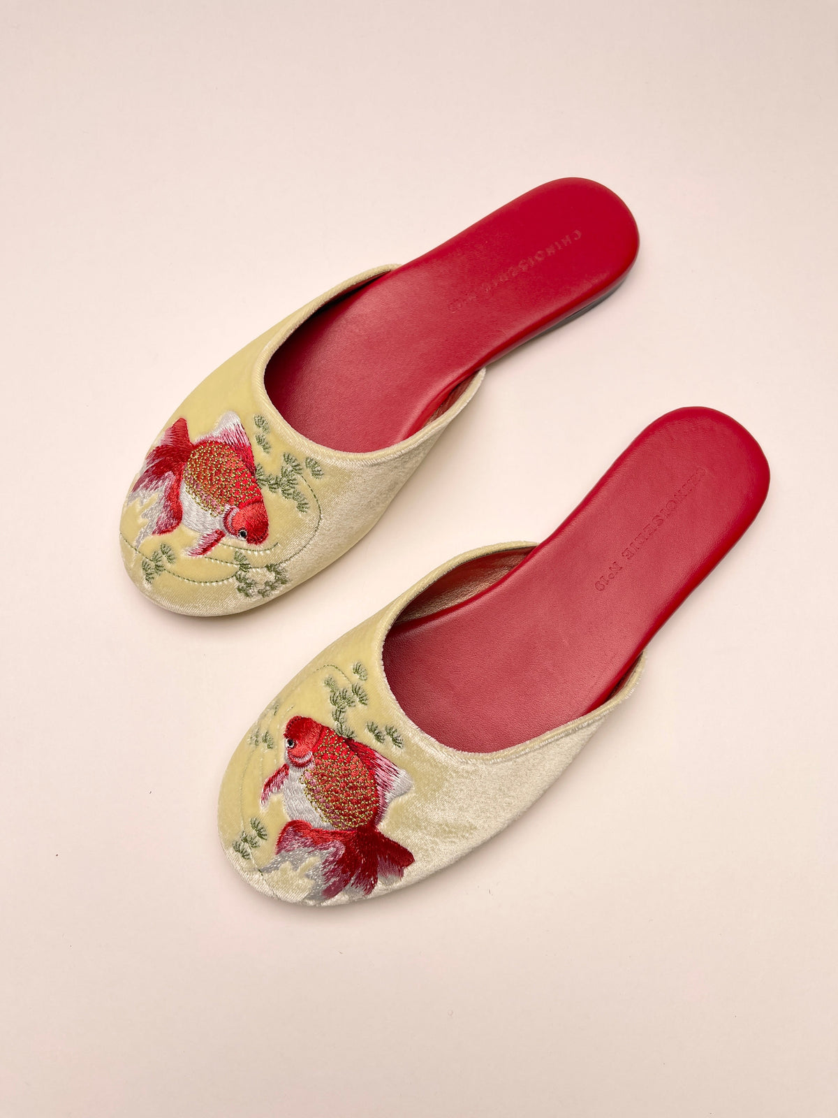 Pair of lemon velvet mules with goldfish embroidery and red insoles