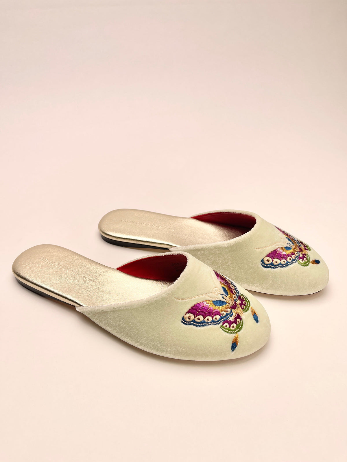 Mint velvet mules, one upside view, butterfly embroidery and red-lined opening