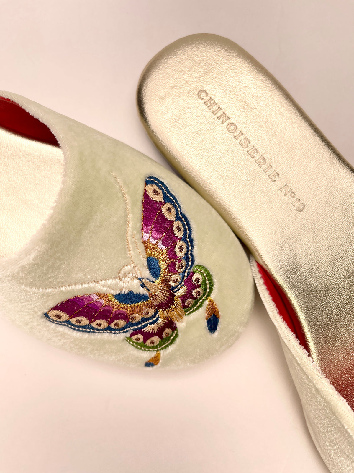 Close-up of mint velvet mule toe with multicolor butterfly embroidery